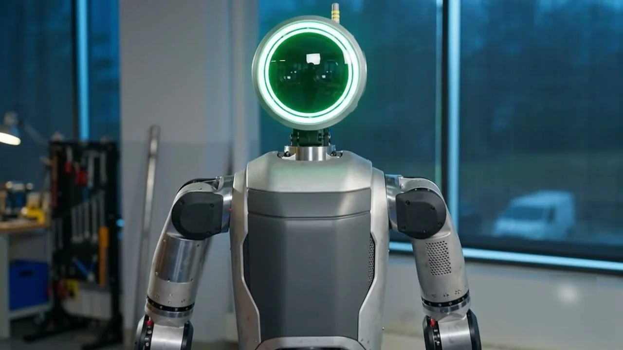 Humanoid robot with an illuminated sensor ring standing in a workshop